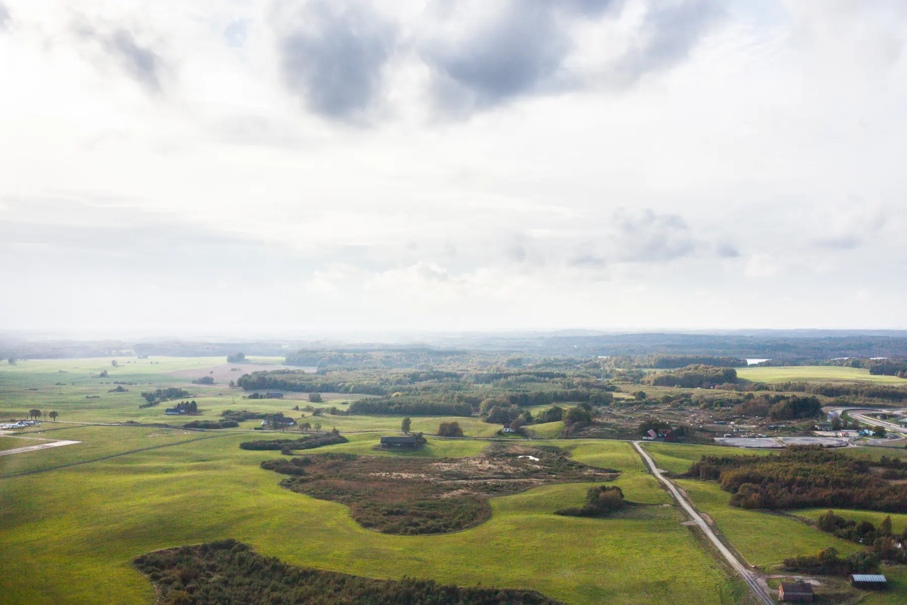 Vista aérea de campos y caminos rurales; terreno llano y despejado.
